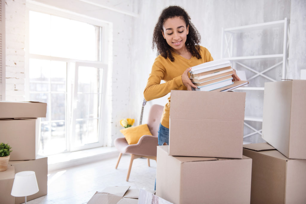girl packing books into boxes